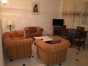 ein Wohnzimmer mit Stühlen, einem Tisch und einem TV in der Unterkunft Maison Dhiefa in Midoun