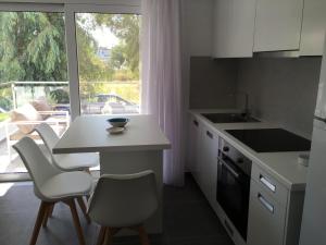 a kitchen with a table and chairs and a window at Nea Stira Studios Kondilia in Nea Stira