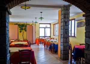 a restaurant with tables and chairs in a room at Agriturismo Le Vigne Ducali in Màndas