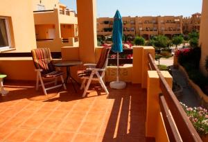 - un balcon avec une table, des chaises et un parasol dans l'établissement Faro WIFI, à Vera