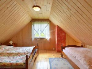 a attic bedroom with two beds and a window at Bieszczadzki Zakątek 787-899-185 in Bukowiec
