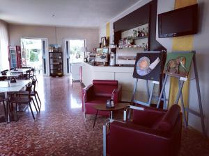 a living room with red chairs and a dining room at Hotel Mirabello in Sirmione