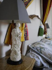 una lampada seduta su un tavolo accanto a un letto di La Minaudière 62 a Boulogne-sur-Mer