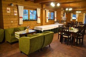 a restaurant with green chairs and tables and a dining room at Drevenica Jánošík 2 in Terchová