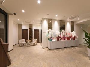 a lobby with a bunch of flowers in vases at S.Training Center Hotel Osaka in Osaka