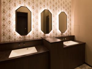 a bathroom with two sinks and two mirrors at S.Training Center Hotel Osaka in Osaka