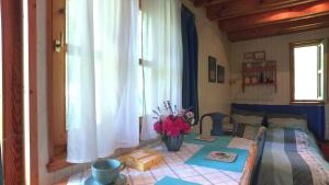 a bedroom with a bed and a table with flowers on it at Rosehill Cottage in Orbányosfa