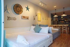une chambre avec un grand lit avec une horloge au mur dans l'établissement My Resort Hua Hin A502, à Hua Hin 21 autres photos