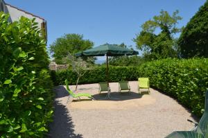 two chairs and an umbrella in a garden at Haus Knott in Polje