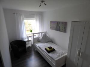 1 dormitorio con 1 cama, 1 silla y 1 ventana en An der Flut 193, en Wilhelmshaven