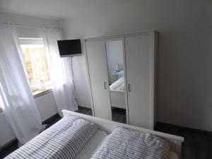 1 dormitorio con cama, tocador y espejo en An der Flut 193, en Wilhelmshaven