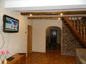 a living room with a television and a staircase at Cabana Florea in Râu de Mori