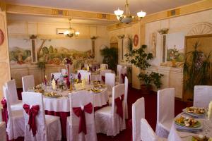 アルバ・ユリアにあるCasa Traianaの白いテーブルと白い椅子が備わる宴会場