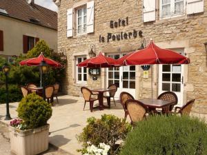 a group of tables and chairs with umbrellas in front of a building at La Poularde in Louhans