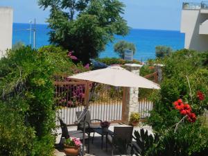 a patio with an umbrella and a table and chairs at Stella Marina Sea & Sun in Cefalù