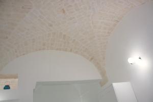 einen Torbogen in einem Zimmer mit weißer Decke in der Unterkunft you & me house in Ceglie Messapica