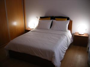 カニコにあるVila Faiaのベッドルーム(白い大型ベッド、ランプ2つ付)