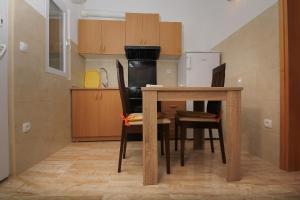 una cucina con tavolo, sedie e frigorifero di Apartment Hello Kitty a Kaštela (Castelli)