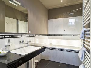 a white bathroom with a tub and a sink at Gästehaus Schloss Saareck in Mettlach