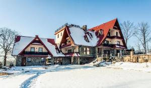 a large house with snow on top of it at Ostrysz in Dzianisz