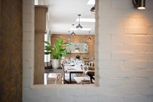 a dining room with tables and chairs and a brick wall at The George Great Oxendon in East Farndon