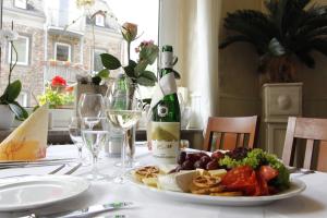 Gasthaus Pension Moselgruss في ديبليخ: طاولة مع زجاجة من النبيذ وصحن من الطعام