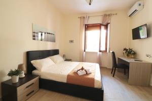 1 dormitorio con cama, escritorio y escritorio en B&B Pietrarsa, en Portici