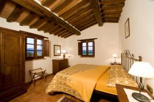 コルトーナにあるFattoria Borgonuovoの木製の天井の客室で、ベッドルーム1室(ベッド1台付)