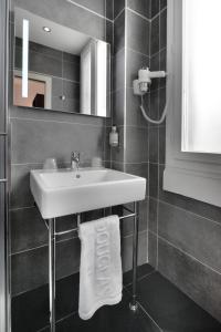 a bathroom with a sink and a mirror at Hotel Douglas in Puteaux