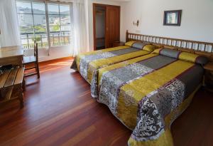 1 dormitorio con 2 camas y piano en As Areas I, en Viveiro