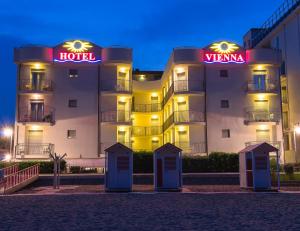 a hotel building with a hotel sign in front of it at Hotel Vienna in Caorle