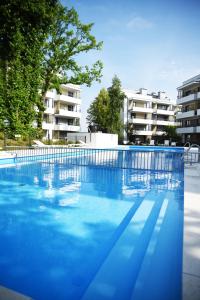 una gran piscina azul con edificios en el fondo en Apartament Szmaragdowy, en Ustronie Morskie