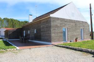 een houten huis met een terras ervoor bij Monte da Barragem in Montargil