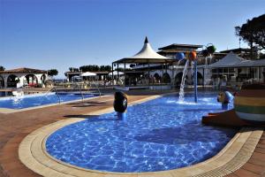 a pool with a water fountain in a resort at Camping Bon Repós in Santa Susanna