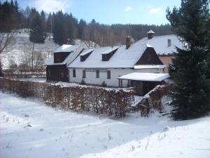 a large white house with snow on its roof at Chalupa za Křížkem in Malá Morávka