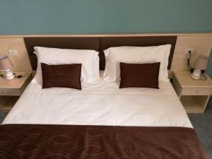 a large white bed with two pillows on it at Hotel Soleluna in Piano di Sorrento