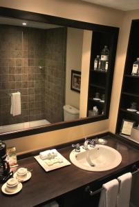 a bathroom with a sink and a mirror at Le St-Martin Bromont Hotel & Suites in Bromont