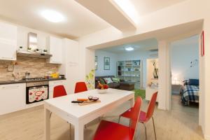 フィレンツェにあるAgnolo garden & fresh marketのキッチン、リビングルーム(白いテーブル、赤い椅子付)