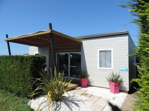 a small white house with a roof at Camping Les Perouses in Saint-Clément-des-Baleines