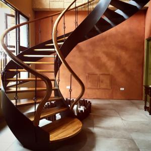 a wooden spiral staircase in a room with a wall at Red Roof B&B in Taitung City