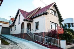 uma casa branca com um telhado vermelho em Heathfield Apartments em Hobart