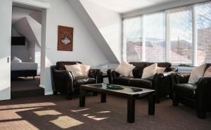 a living room with leather chairs and a coffee table at Heathfield Apartments in Hobart