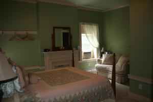een slaapkamer met groene muren, een bed en een raam bij The 1819 Red Brick Inn in Dundee
