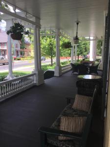 - une terrasse couverte avec des chaises et une table et une vue sur une rue dans l'établissement The Inn at Montpelier, à Montpelier