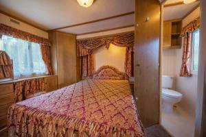 a bedroom with a bed and a toilet at Domek Promyk in Jurata