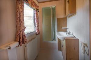 a bathroom with a sink and a window at Domek Promyk in Jurata +22 photos