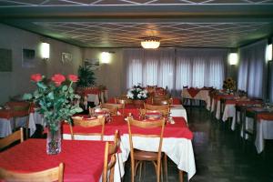 サウゼ・ドゥルクスにあるHotel Villa Caryの赤いテーブルと椅子、花が飾られたダイニングルーム