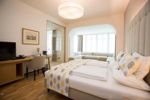 Dormitorio con cama, escritorio y TV en Suiten Schloss Finkenstein en Gödersdorf