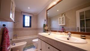 a bathroom with two sinks and a toilet and a mirror at Golf Apartment in Majadahonda +10 photos