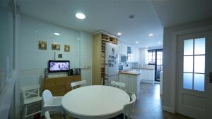 a room with a white table and chairs and a kitchen at Golf Apartment in Majadahonda